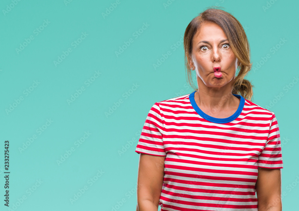 Middle age senior hispanic woman over isolated background making fish face with lips, crazy and comical gesture. Funny expression. Middle age senior hispanic woman over isolated background making fish face with lips, crazy and comical gesture. Funny expression.
