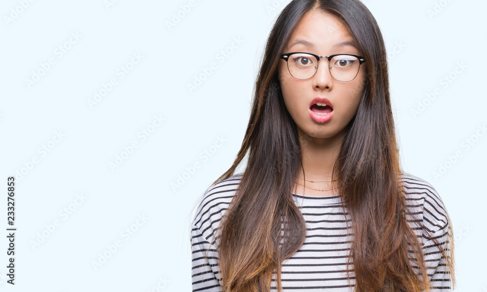 Young asian woman wearing glasses over isolated background afraid and shocked with surprise expression, fear and excited face. Young asian woman wearing glasses over isolated background afraid and shocked with surprise expression, fear and excited face.