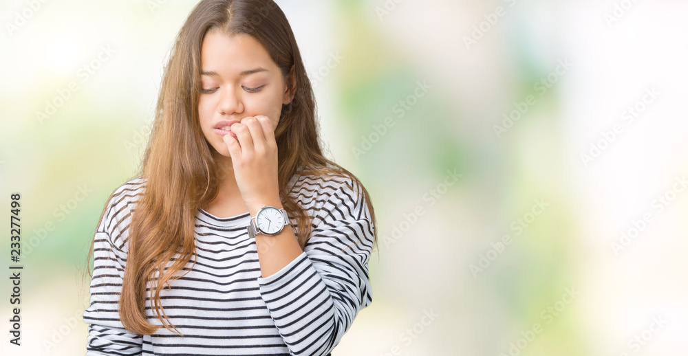 Young beautiful brunette woman wearing stripes sweater over isolated background looking stressed and nervous with hands on mouth biting nails. Anxiety problem. Young beautiful brunette woman wearing stripes sweater over isolated background looking stressed and nervous with hands on mouth biting nails. Anxiety problem.