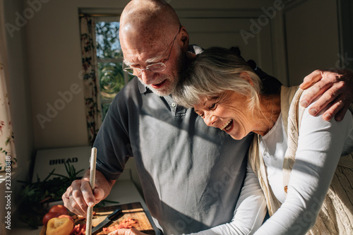 Fotografie Senior couple cooking food together standing in kitchen