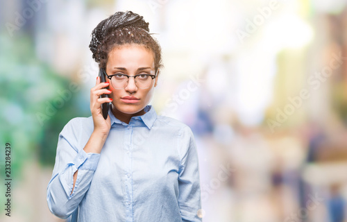 Young braided hair african american business girl showing calling using smartphone over isolated background with a confident expression on smart face thinking serious