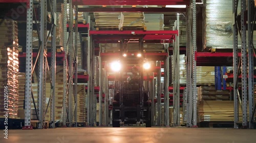 The driver on the loader moves through the warehouse along the rows