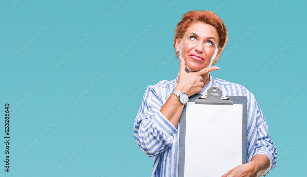 Senior caucasian business woman holding clipboard over isolated background serious face thinking about question, very confused idea Senior caucasian business woman holding clipboard over isolated background serious face thinking about question, very confused idea