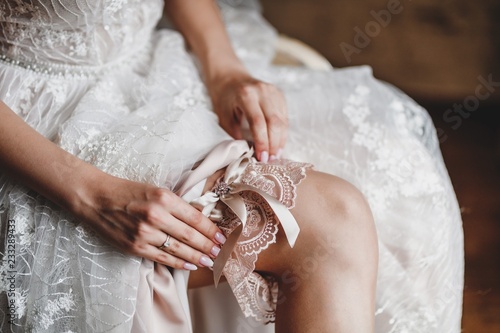 The bride wears a garter on her wedding day. photo