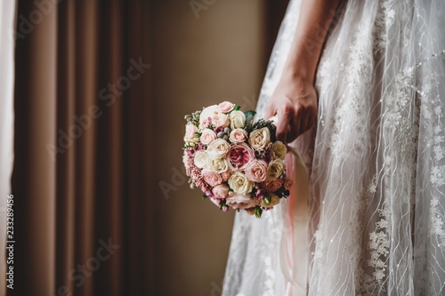 Beautiful bride's bouquet with different flowers. Hands of newlyweds.