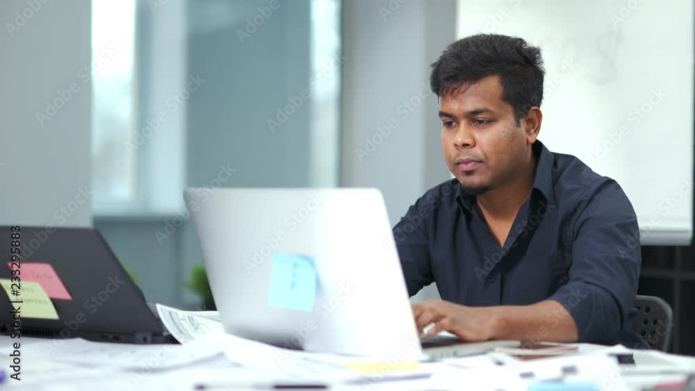 Portrait of enthusiastic African man working typing text using laptop PC at modern workplace Portrait of enthusiastic African man working typing text using laptop PC at modern workplace