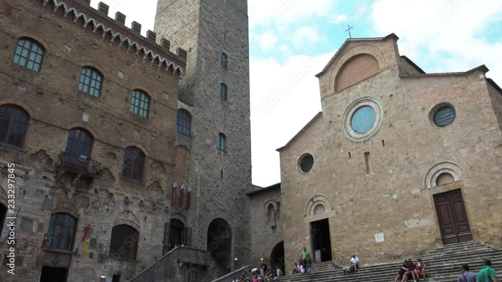 Tourists walking around Duomo and medieval towers. People on vacation visiting cathedral and buildings. Italian attraction, sightseeing, tourism destination. San Gimignano, Tuscany, Italy Tourists walking around Duomo and medieval towers. People on vacation visiting cathedral and buildings. Italian attraction, sightseeing, tourism destination. San Gimignano, Tuscany, Italy