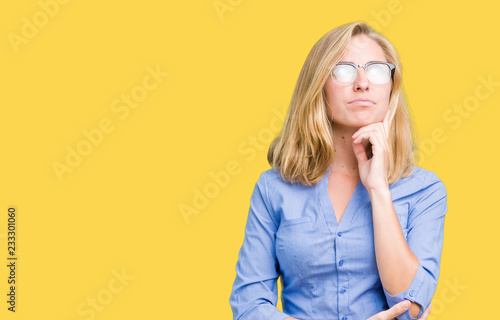 Beautiful young business woman over isolated background with hand on chin thinking about question, pensive expression. Smiling with thoughtful face. Doubt concept.