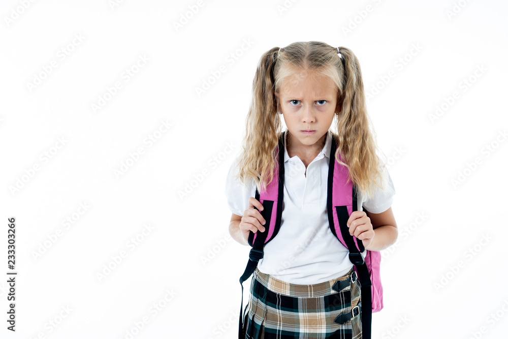 Sad little girl in school uniform carrying a big backpack feeling overwhelmed and angry Sad little girl in school uniform carrying a big backpack feeling overwhelmed and angry