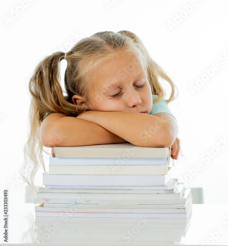 Exhausted schoolgirl falling asleep on her books after studying too much