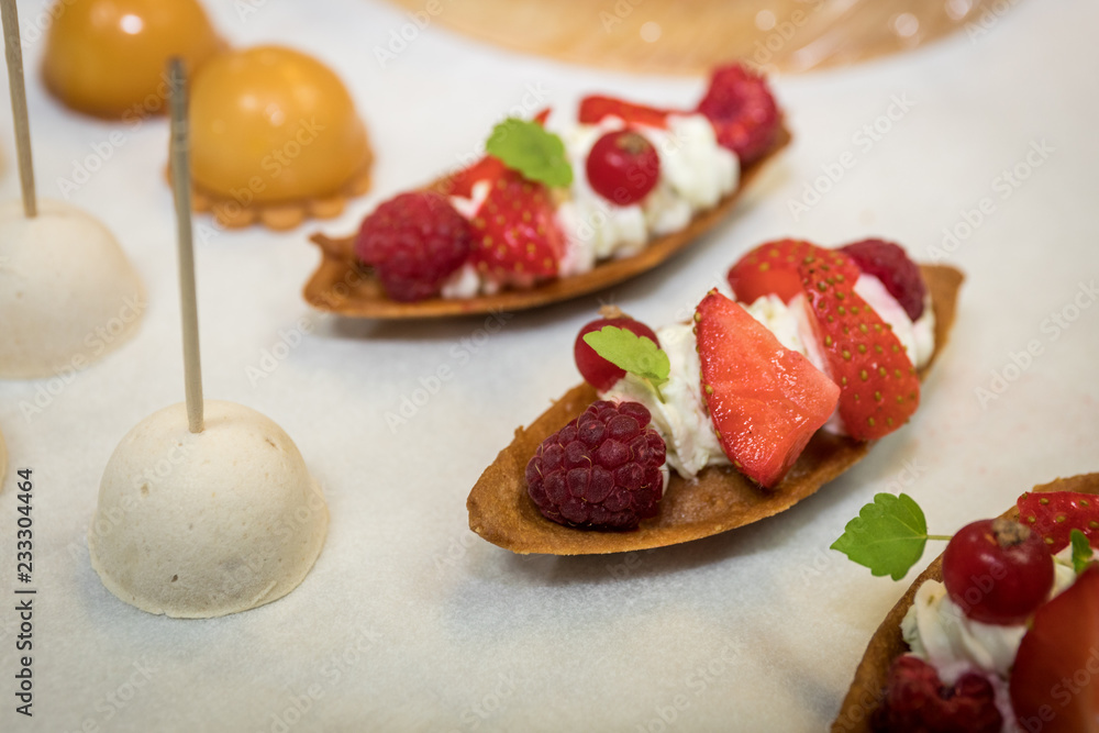 Desserts made of pastries and fresh fruits aligned on a table Desserts made of pastries and fresh fruits aligned on a table