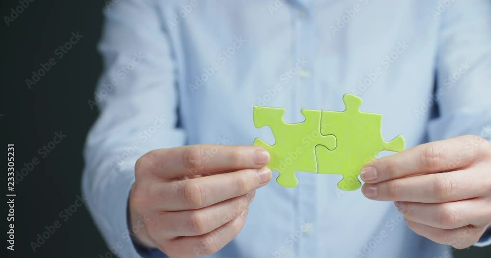 Woman joining puzzle pieces together. Chroma key compositing possible. Woman joining puzzle pieces together. Chroma key compositing possible.