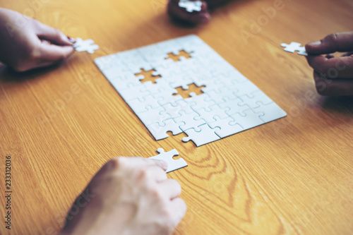 close up hand of group business partnership people puting together a jigsaw puzzle , business teamwork Strategy concept