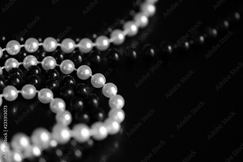 Necklace of black and white beads on a dark background close up. Black and white Necklace of black and white beads on a dark background close up. Black and white