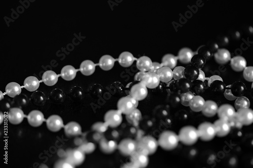Necklace of black and white beads on a dark background close up. Black and white