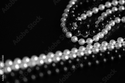 Necklace of black and white beads on a dark background close up. Black and white