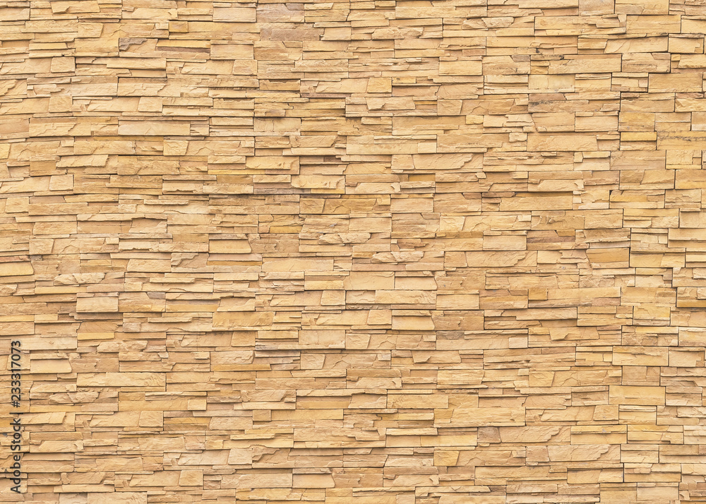 Rock stone brick tile wall aged texture detailed pattern background in light yellow cream brown color Rock stone brick tile wall aged texture detailed pattern background in light yellow cream brown color