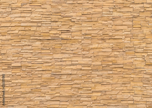 Rock stone brick tile wall aged texture detailed pattern background in dark cream beige brown color