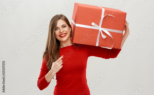 happy woman holding red ift box on shoulder and finger gesture. photo