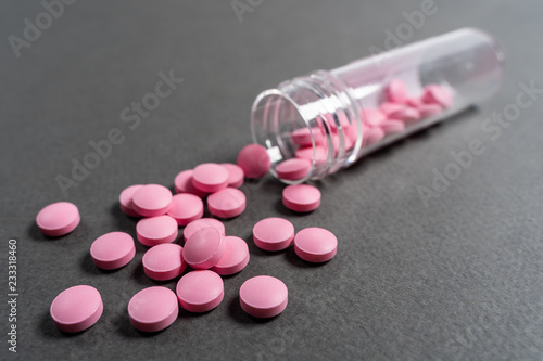 Pink medicine pills on a grey background