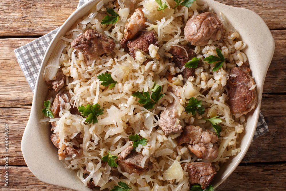 Rustic style Estonian mulgikapsas stewed pork with sauerkraut, onions and barley closeup in a dish. Horizontal top view Rustic style Estonian mulgikapsas stewed pork with sauerkraut, onions and barley closeup in a dish. Horizontal top view