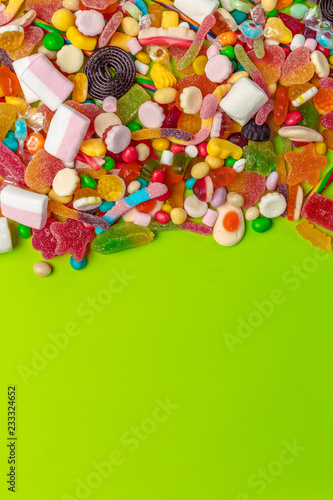 Colorful candies on green background