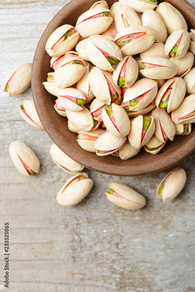 pistachio nuts with shell on the wooden board, top view pistachio nuts with shell on the wooden board, top view