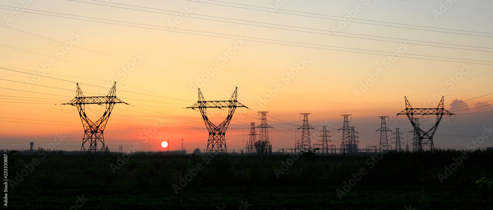 In the evening, the silhouette of high voltage towers