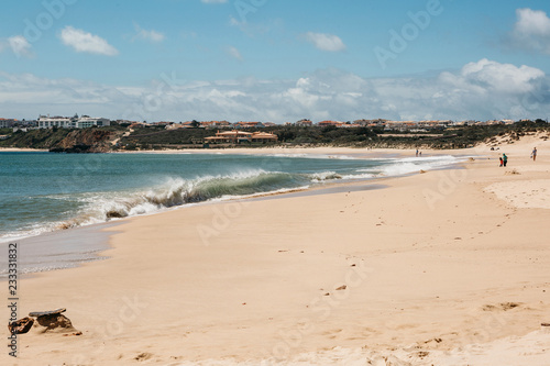 Waves at the beach off the coast of Portugal. Atlantic Ocean. People rest on the beach.