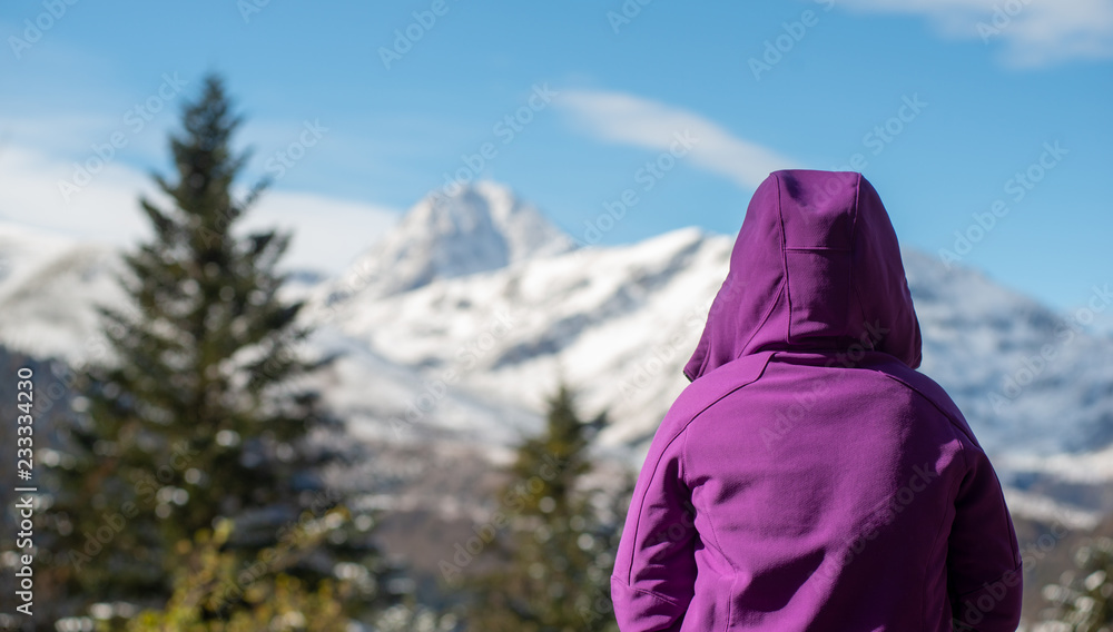 woman dressed in purple looking at the snowy mountain woman dressed in purple looking at the snowy mountain