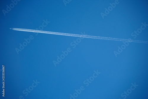 wake of plane clouds blue sky