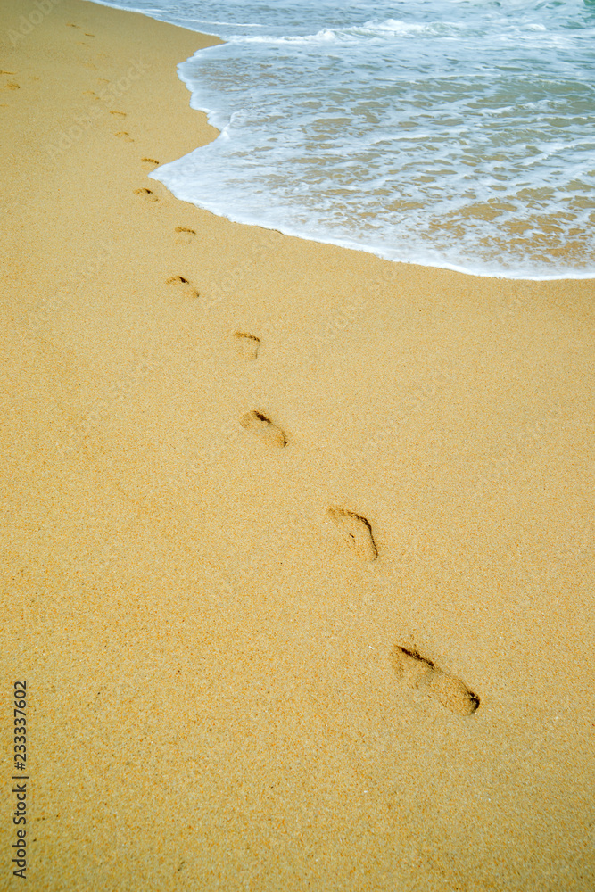 woman relaxing walking on sand beach leaving footprints in the sand. woman relaxing walking on sand beach leaving footprints in the sand.