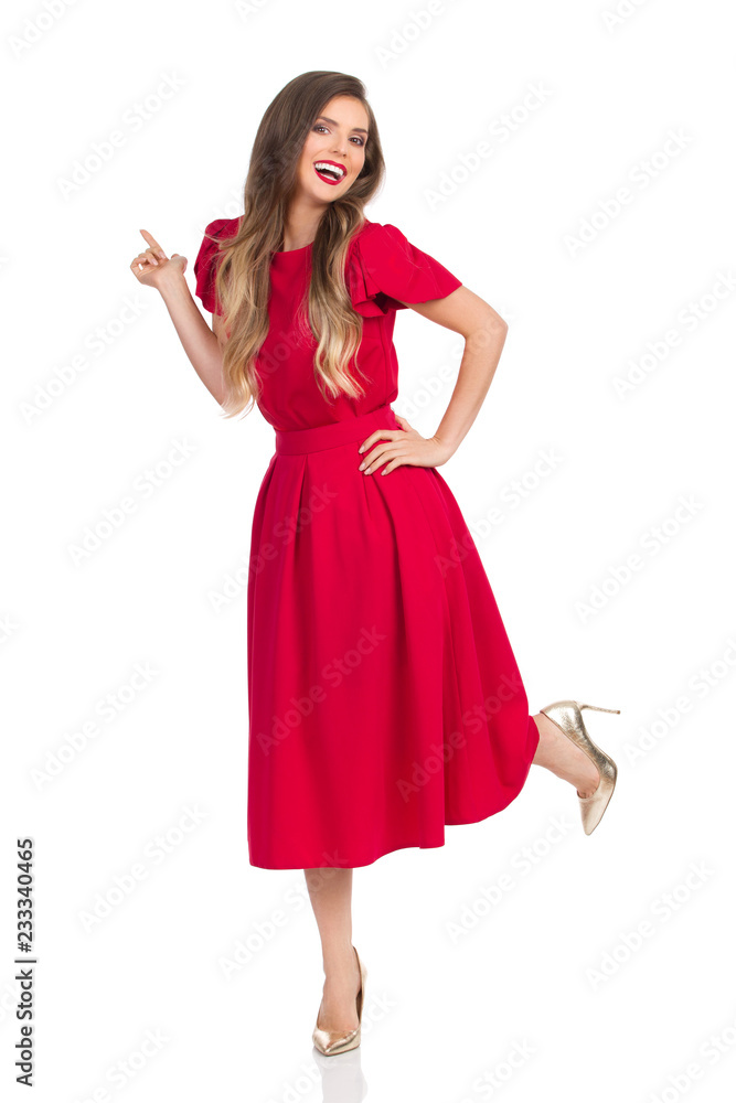 Laughing Beautiful Young Woman In Red Dress And High Heels Is Standing On One Leg