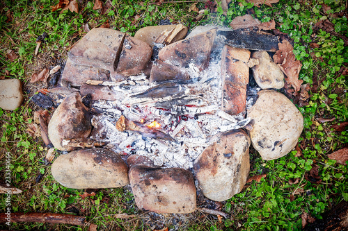 burning firewood on small campire surrounded by stones