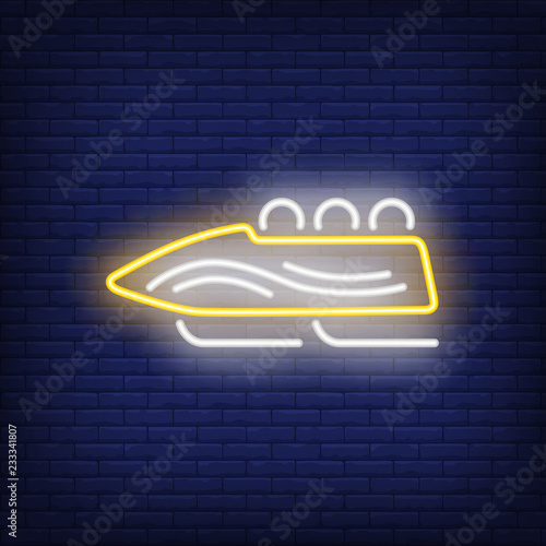Yellow bobsleigh neon sign. Glowing bob with sport team on dark blue brick background. Can be used for sport, winter games, Olympic