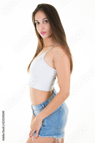 Standing smiling teenage girl in fashion clothes and blue short, young woman, isolated on white background © OceanProd
