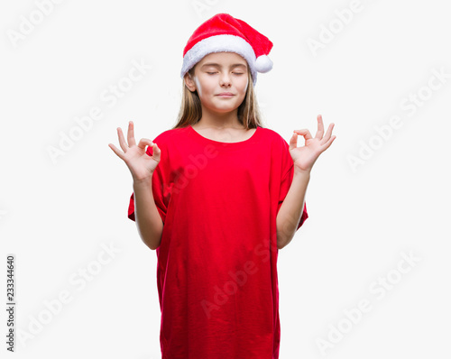 Young beautiful girl wearing christmas hat over isolated background relax and smiling with eyes closed doing meditation gesture with fingers. Yoga concept.