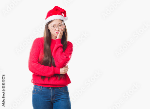 Young Chinese woman over isolated background wearing christmas hat thinking looking tired and bored with depression problems with crossed arms.