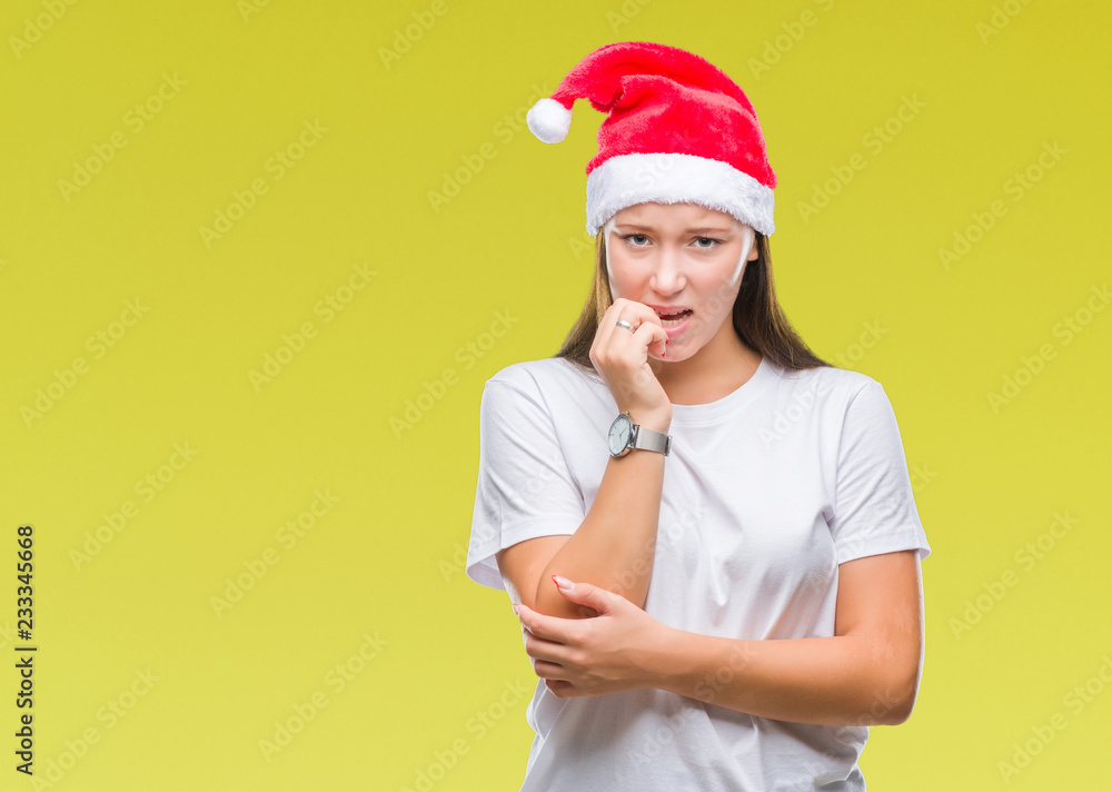 Young beautiful caucasian woman wearing christmas hat over isolated background looking stressed and nervous with hands on mouth biting nails. Anxiety problem.