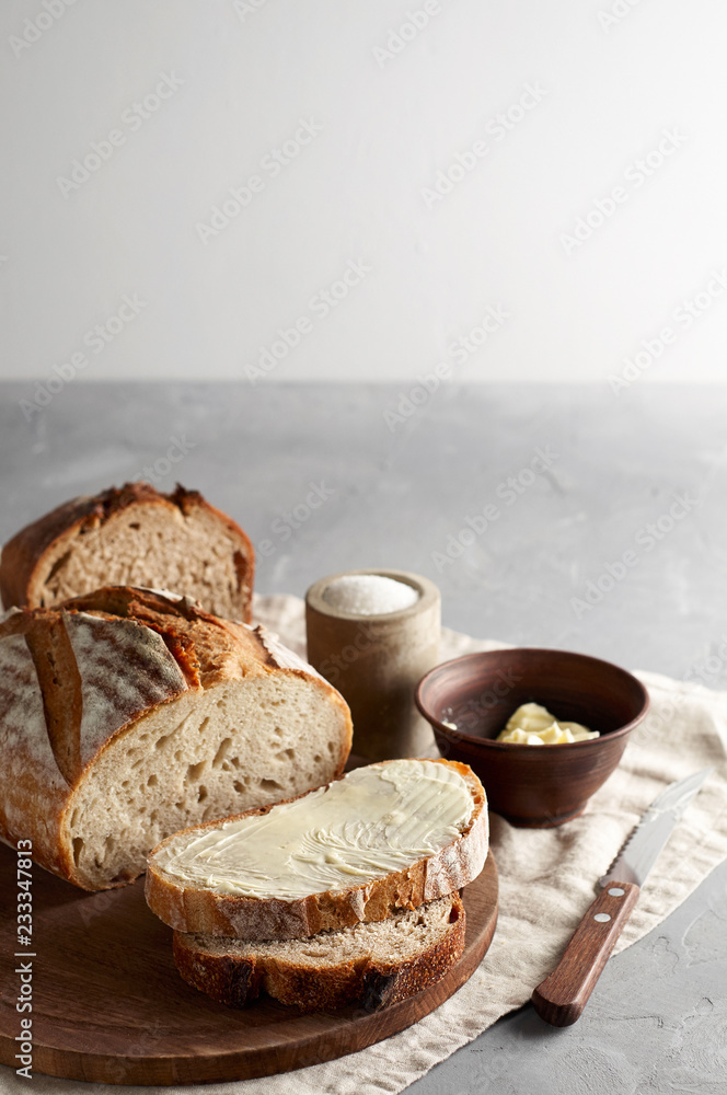 Artisan sliced toast bread with butter and sugar on wooden cutting board