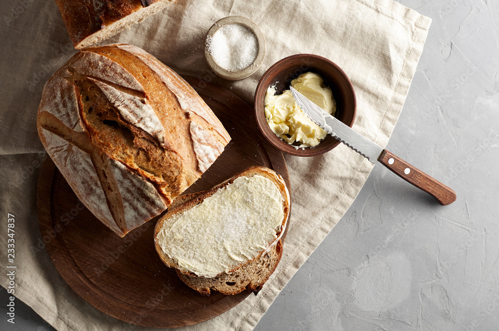 Artisan sliced toast bread with butter and sugar on wooden cutting board