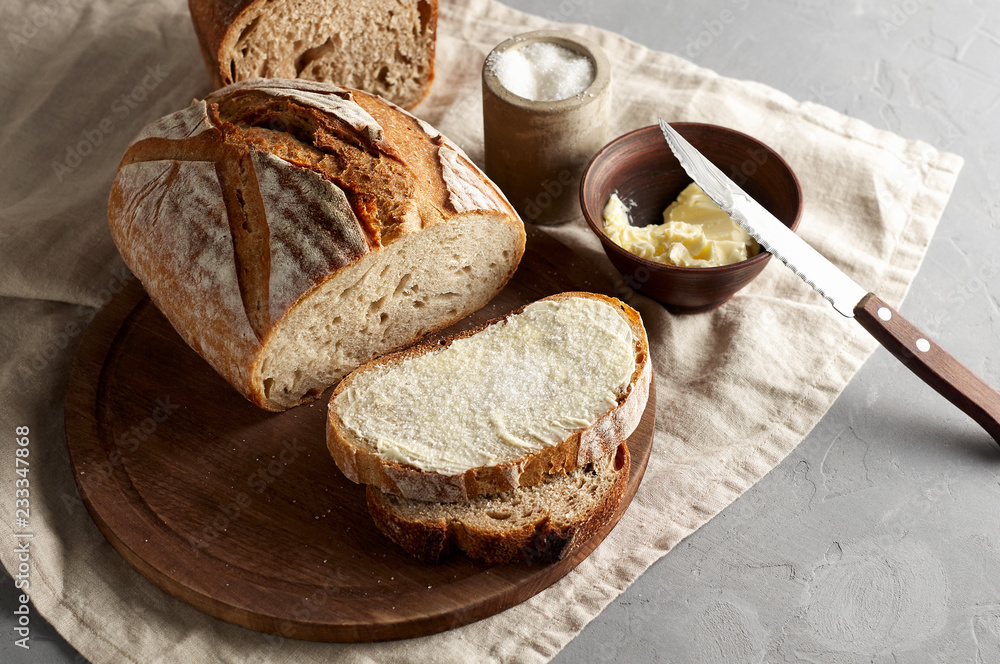 Artisan sliced toast bread with butter and sugar on wooden cutting board