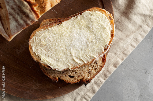 Artisan sliced toast bread with butter and sugar on wooden cutting board
