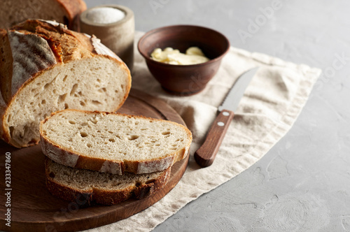 Artisan sliced toast bread with butter and sugar on wooden cutting board