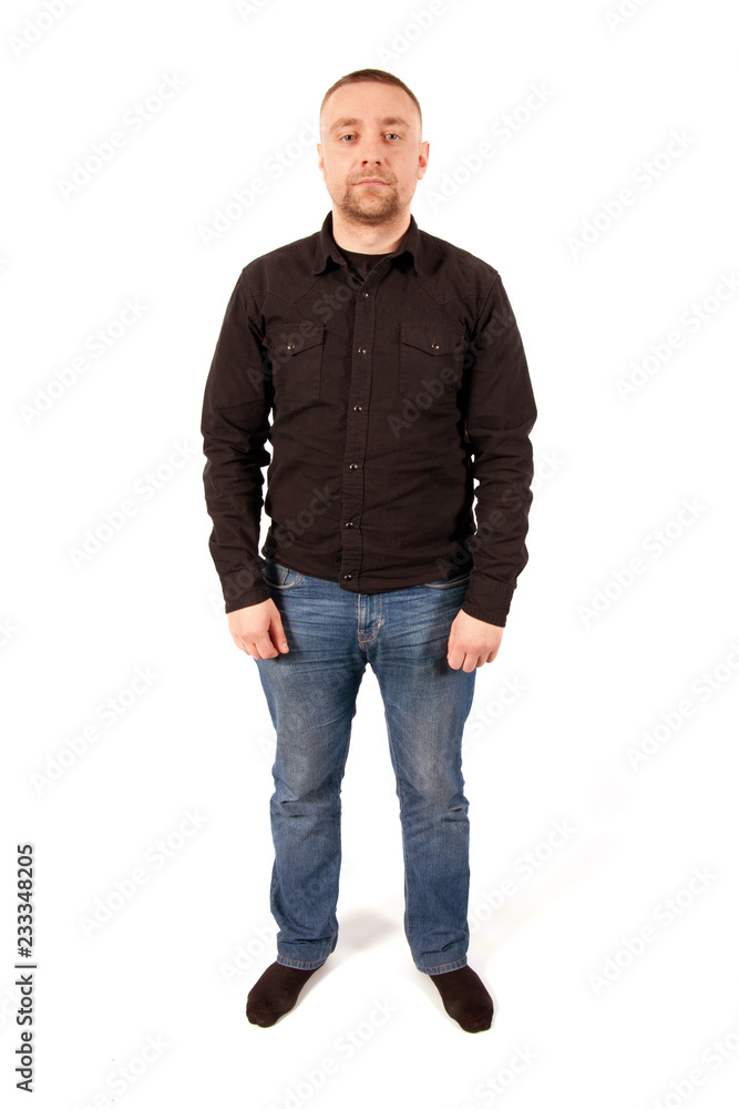 A young man dressed in jeans and a black shirt standing on white background A young man dressed in jeans and a black shirt standing on white background