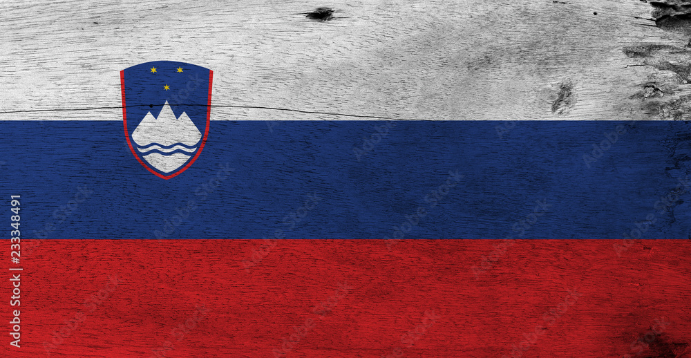 Flag of Slovenia on wooden plate background. Grunge Slovenian flag texture, White blue and red, charged with the Coat of arms at the hoist side. Flag of Slovenia on wooden plate background. Grunge Slovenian flag texture, White blue and red, charged with the Coat of arms at the hoist side.