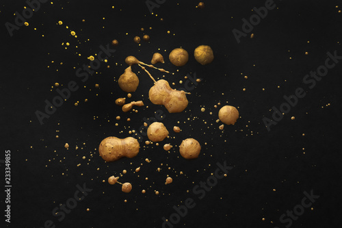 Blots of gold paint on dark background