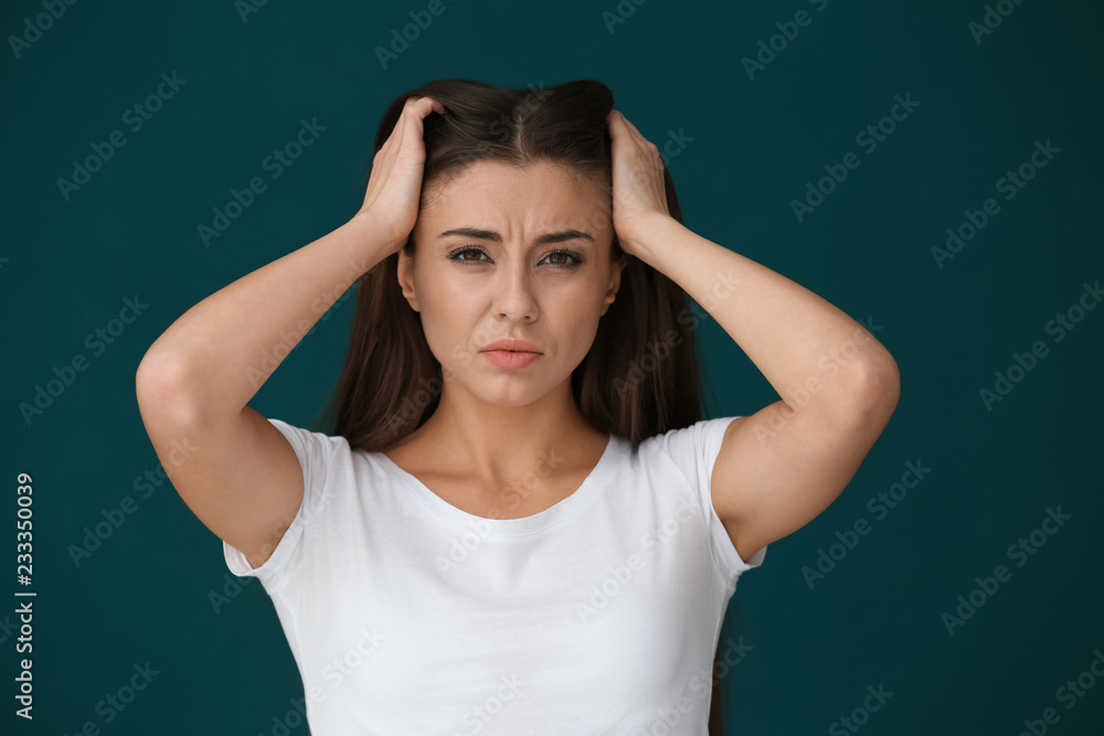 Woman suffering from headache on color background Woman suffering from headache on color background