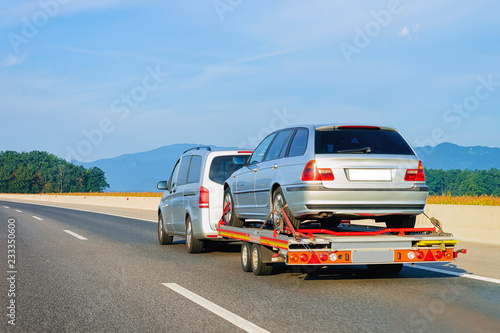 Foto Car carrying trailer with new vehicle in road in Slovenia