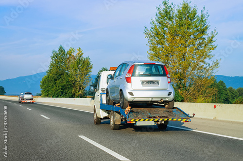 Tow truck transporter carrying car in Road in Slovenia